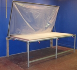 Wall mounted vacuum frame press. Vacuum frame press mounted to wall and folds up out of the way