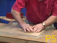 Pushing the veneer down over the corner of a raised panel in a vacuum bag